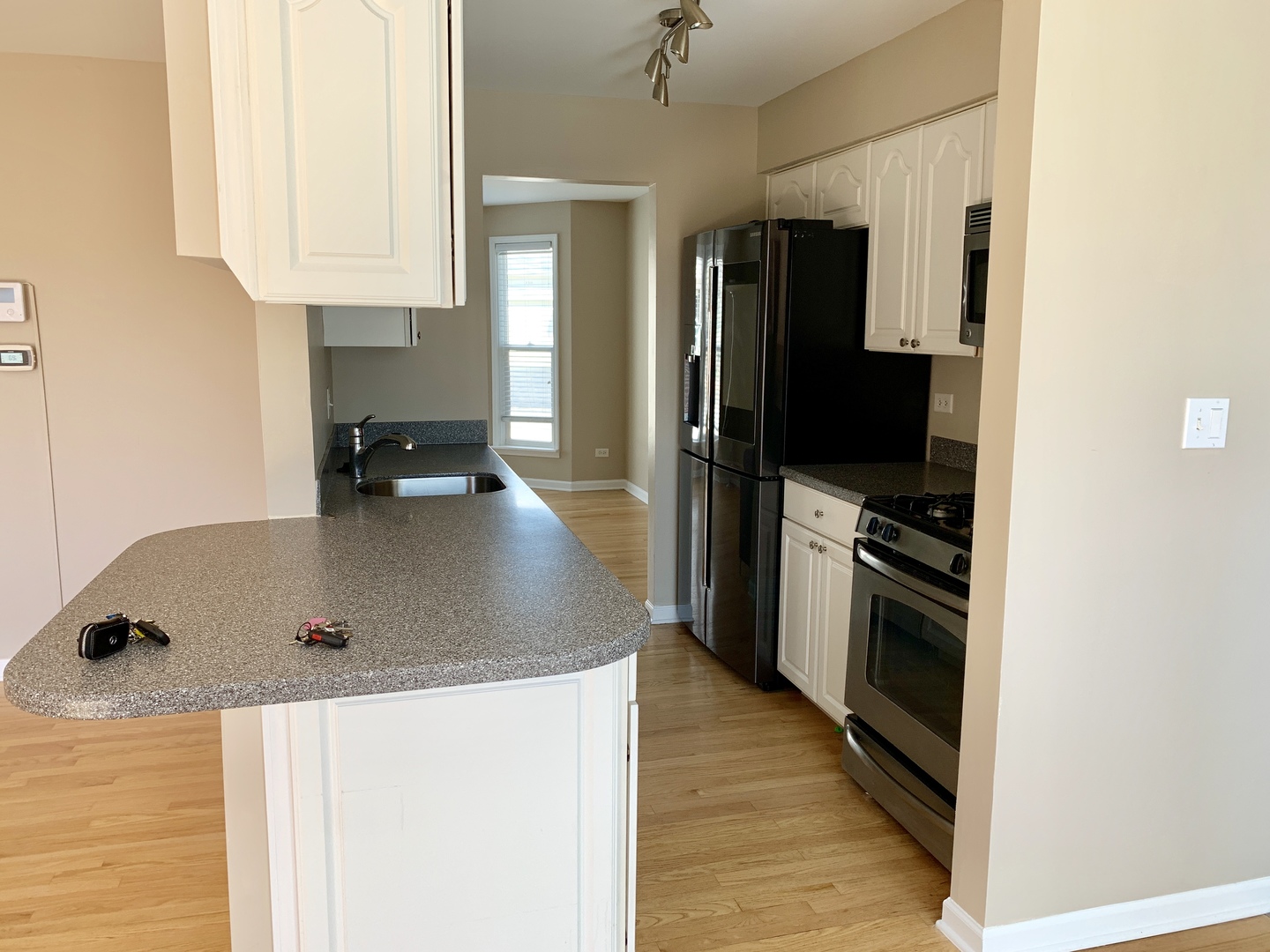 a kitchen with stainless steel appliances granite countertop a sink a stove and a refrigerator