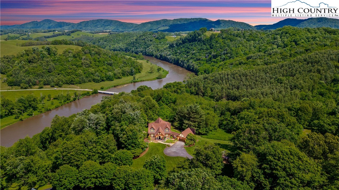 an aerial view of a house with a garden and mountains