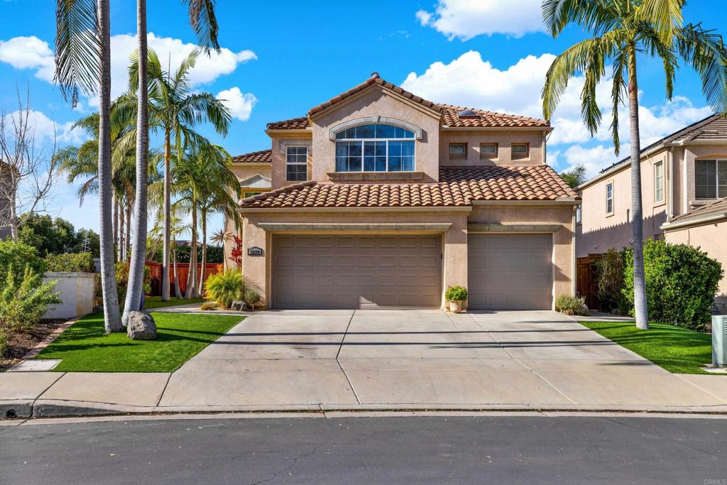 a view of a house with a yard and palm trees