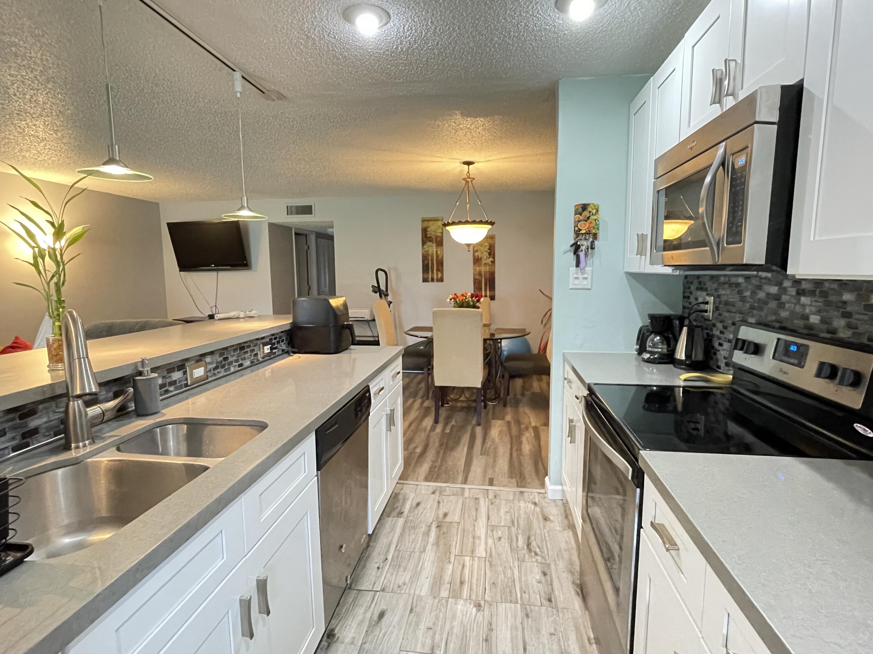 a kitchen with a sink stove top oven and microwave