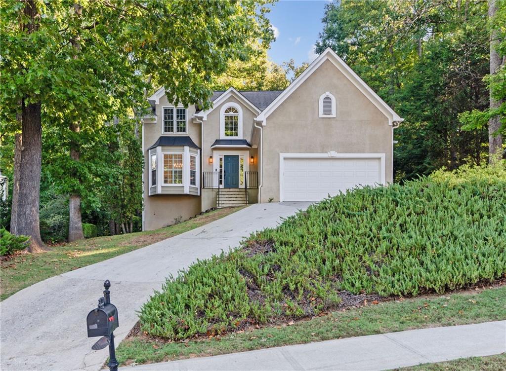 a front view of a house with a yard and trees