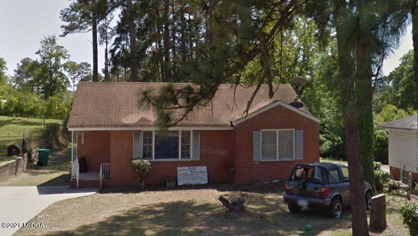 a front view of a house with a garden and yard