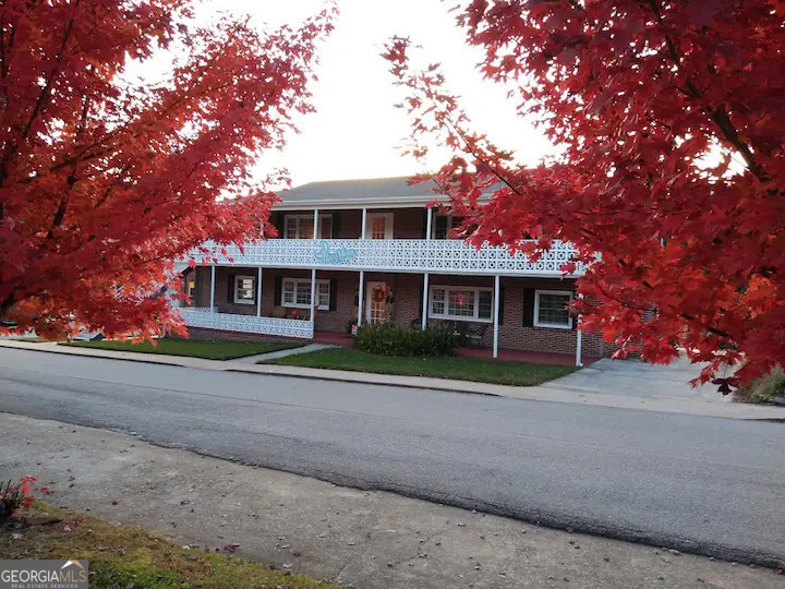 a front view of a house with a yard and trees