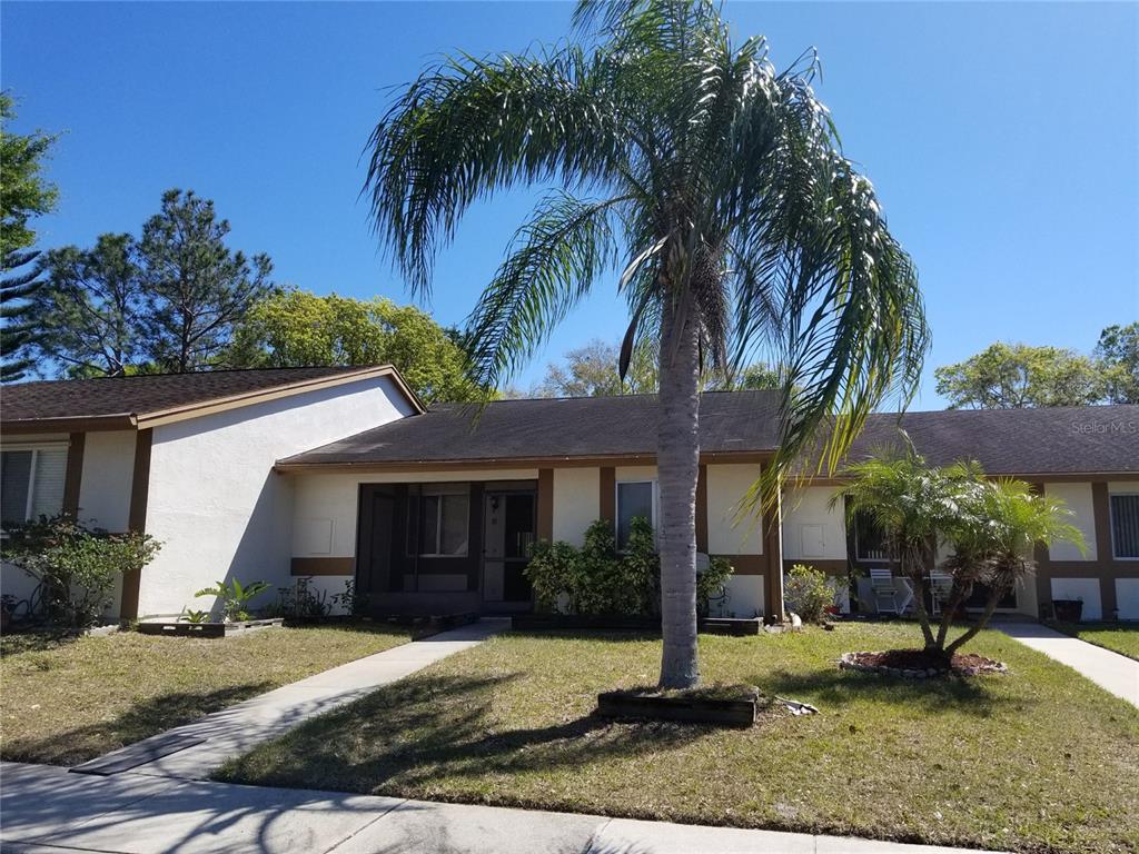 a view of a house with a yard and palm tree