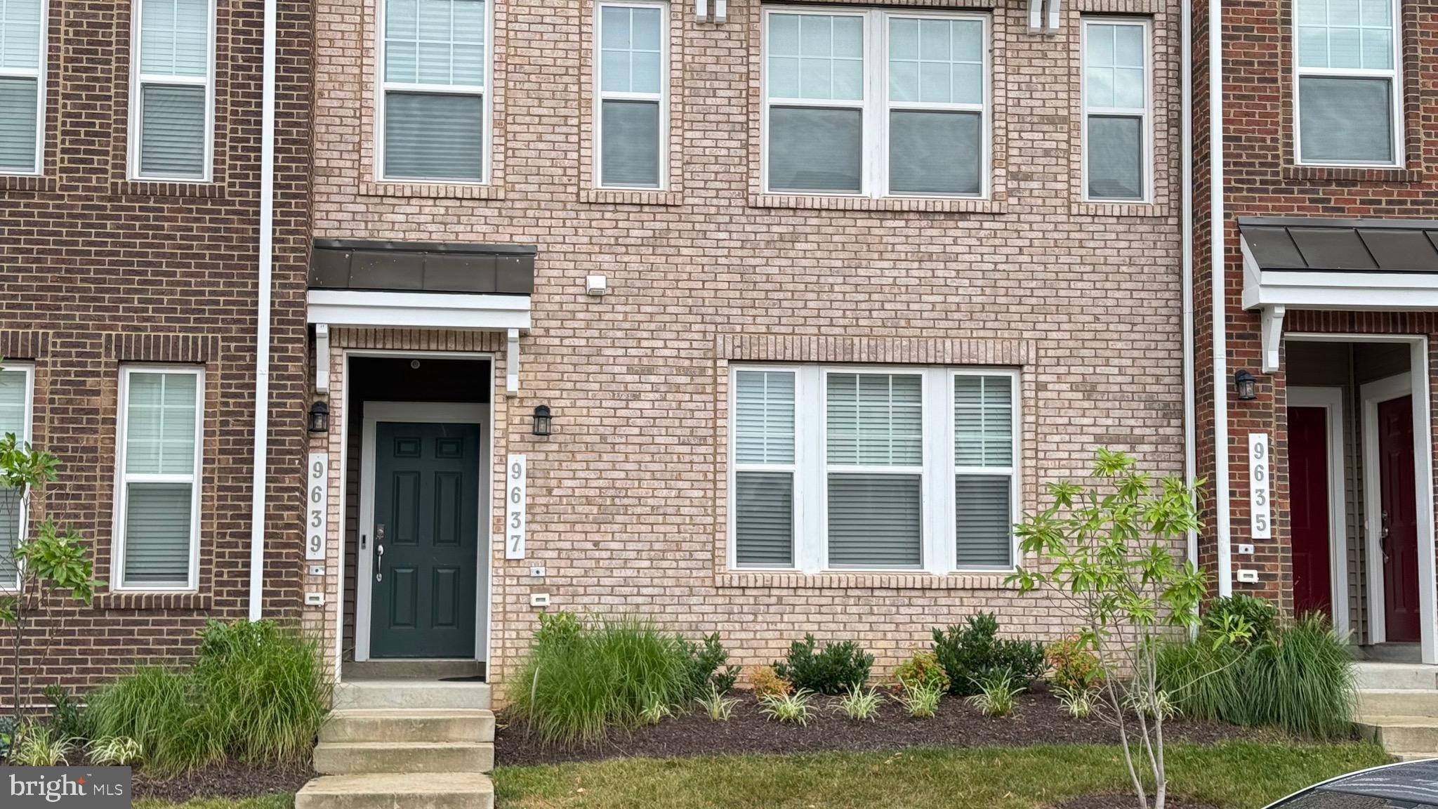 a front view of a house with a yard and potted plants