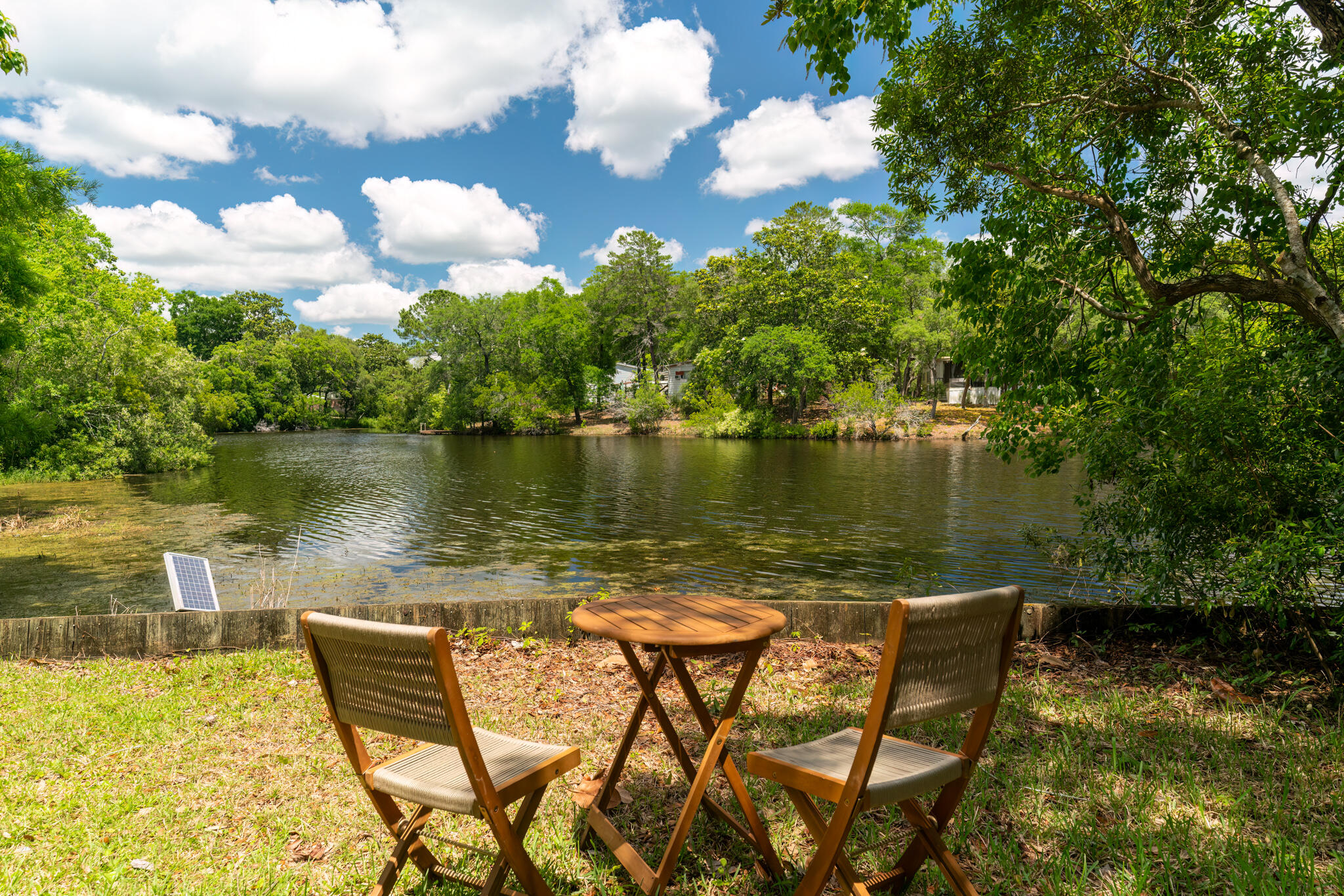 a view of a lake with table and chairs