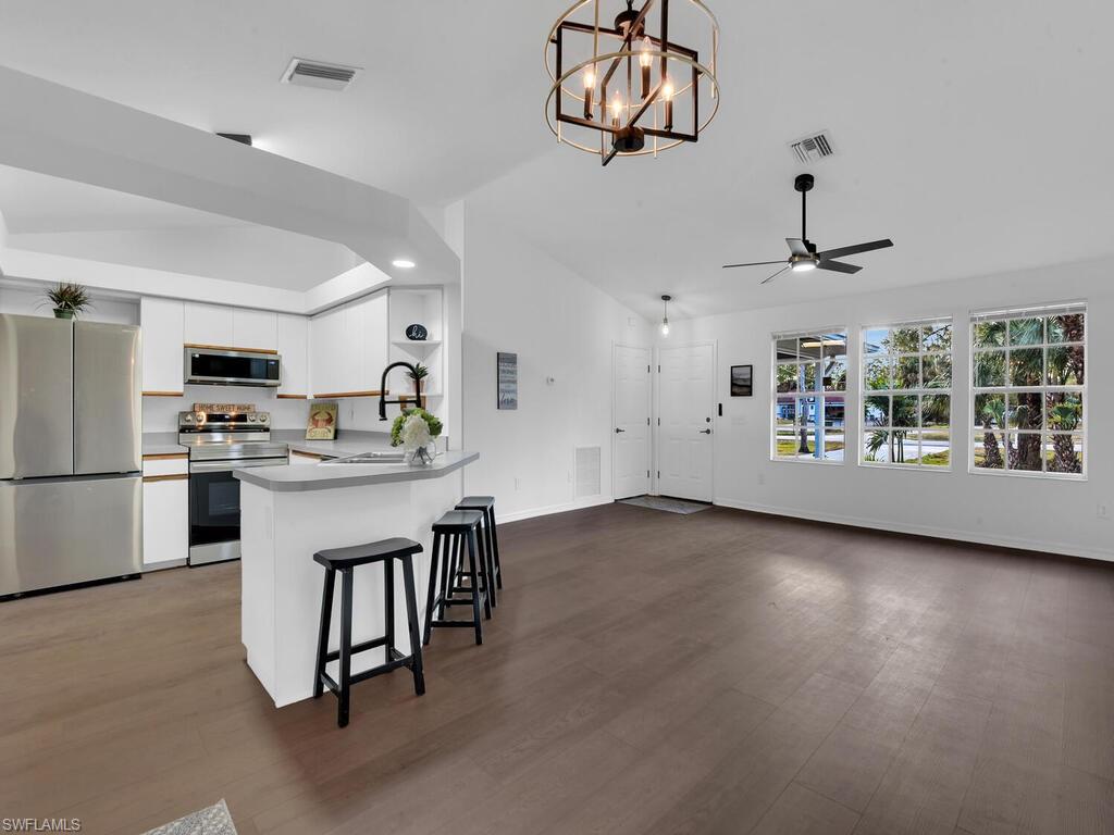 a kitchen with kitchen island white cabinets and stainless steel appliances