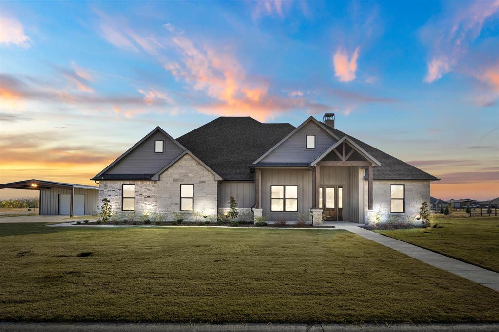 View of front of house with a lawn and a carport