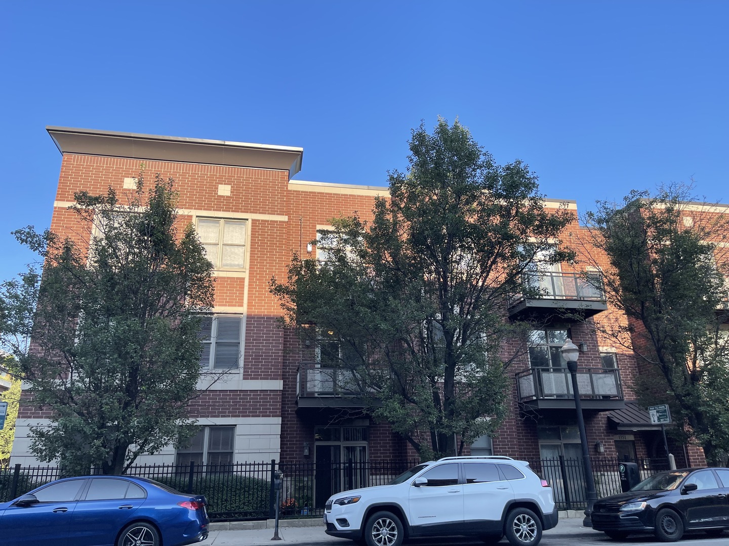 a front view of a building with trees