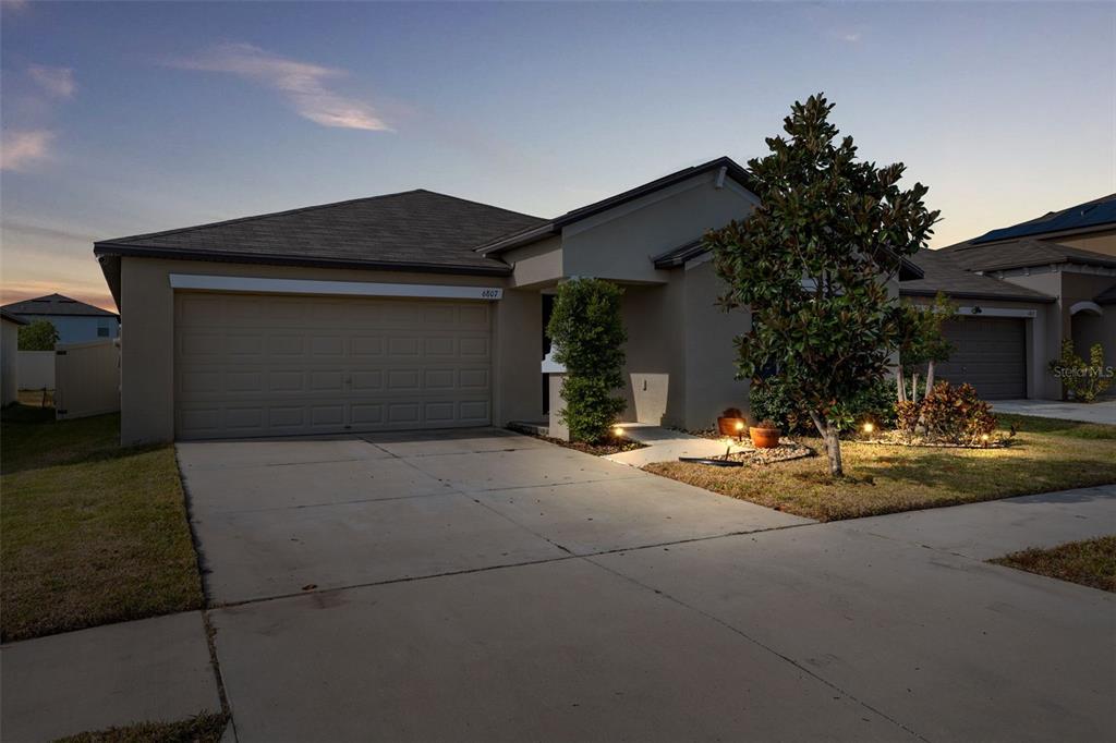 a front view of a house with yard and garage