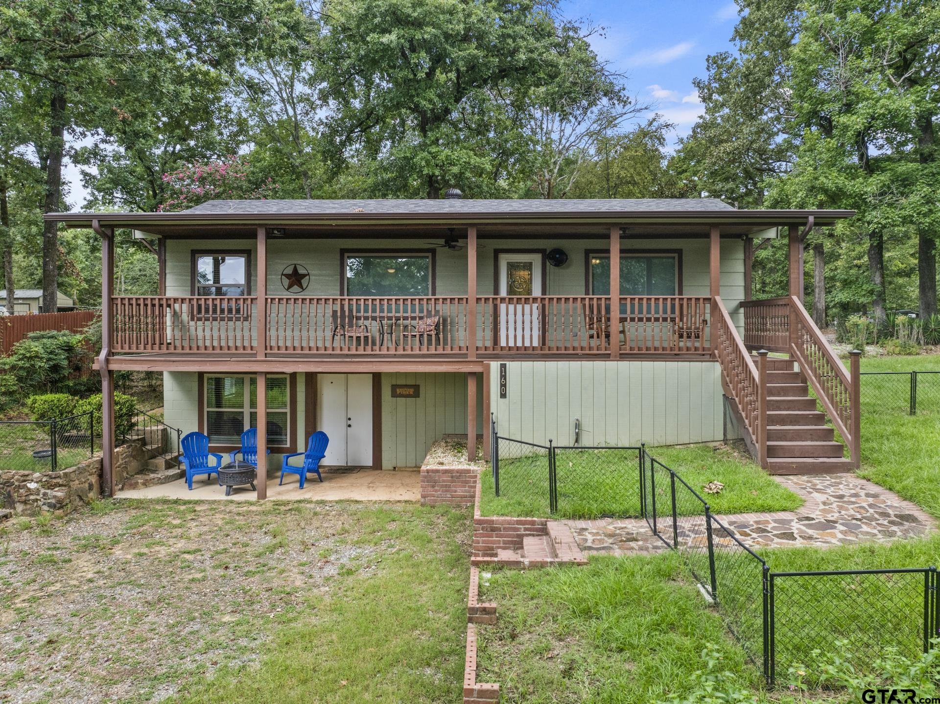 a view of a house with a yard and lawn chairs