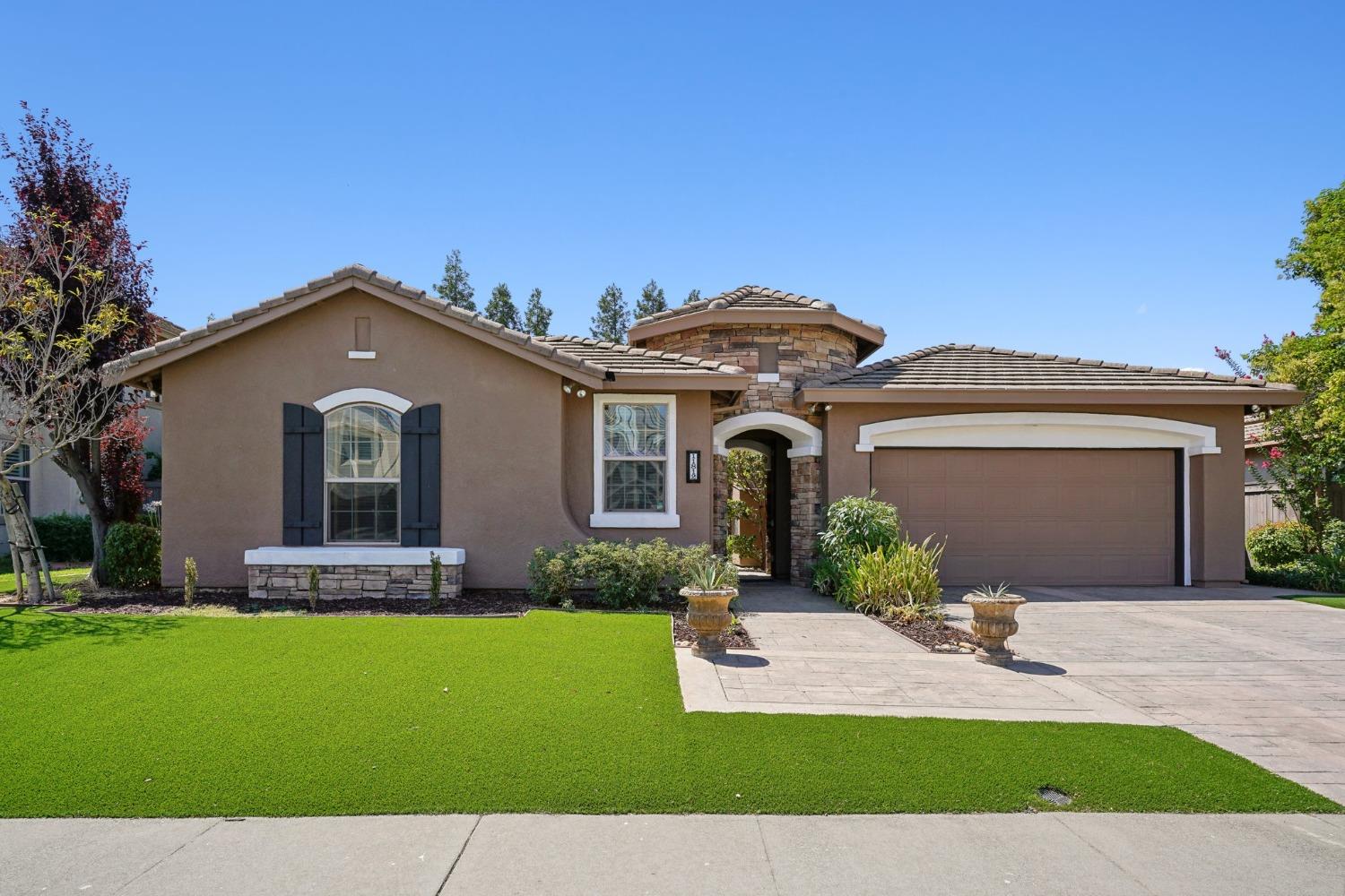 a front view of a house with a yard and garage