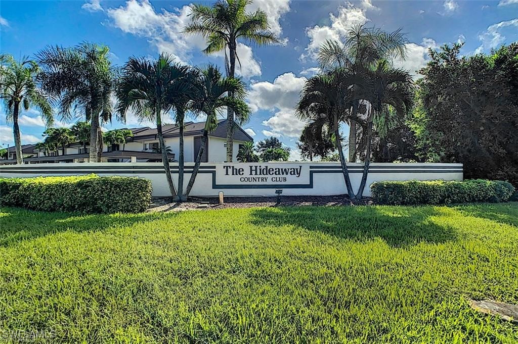 a view of house with a yard and palm trees