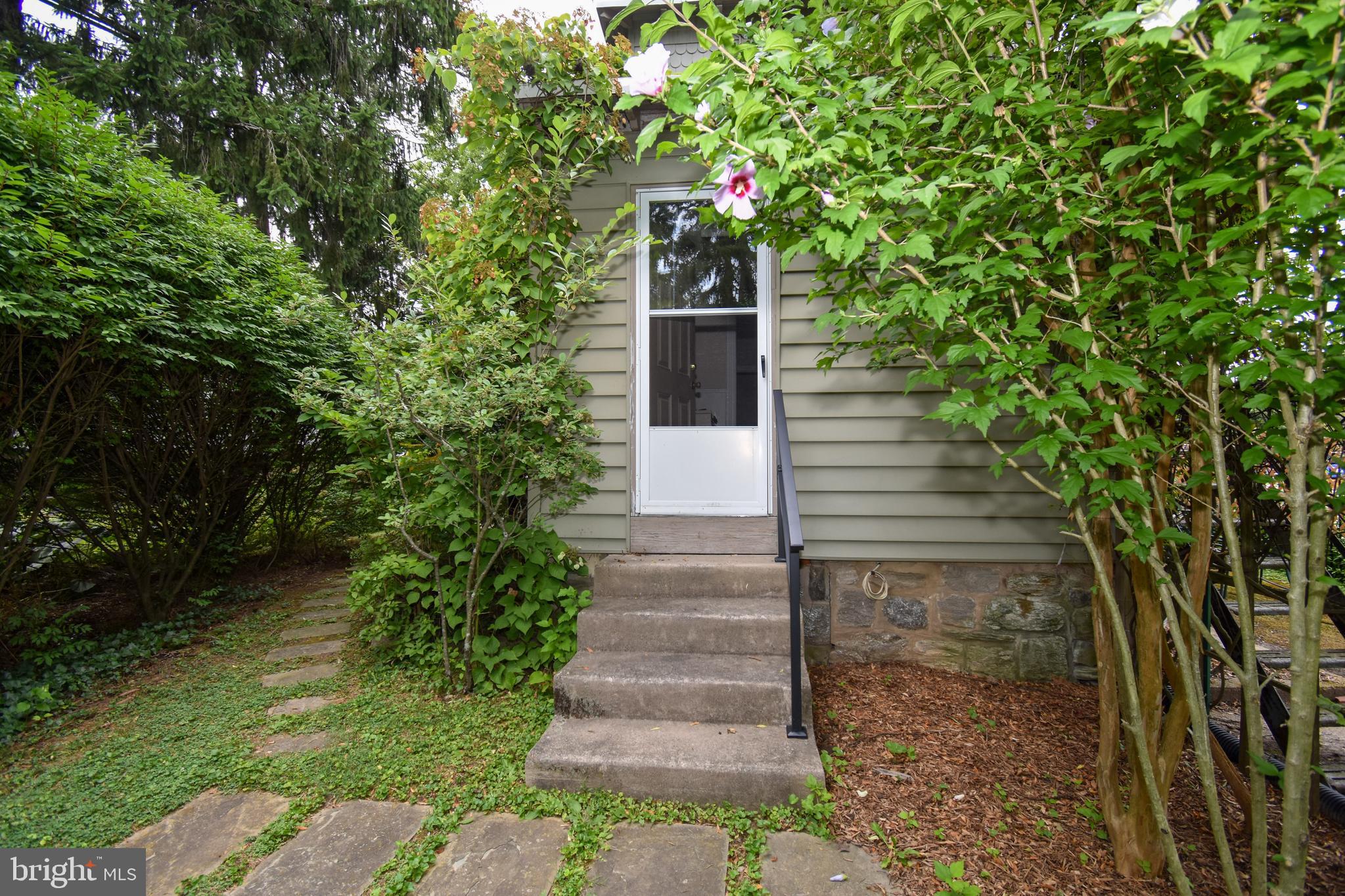 a front view of a house with plants and garden