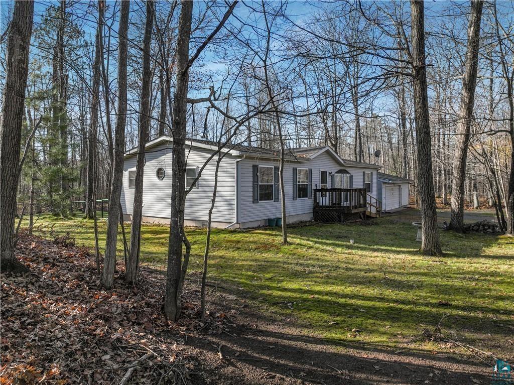 View of property exterior with a yard, an outbuilding, and a garage