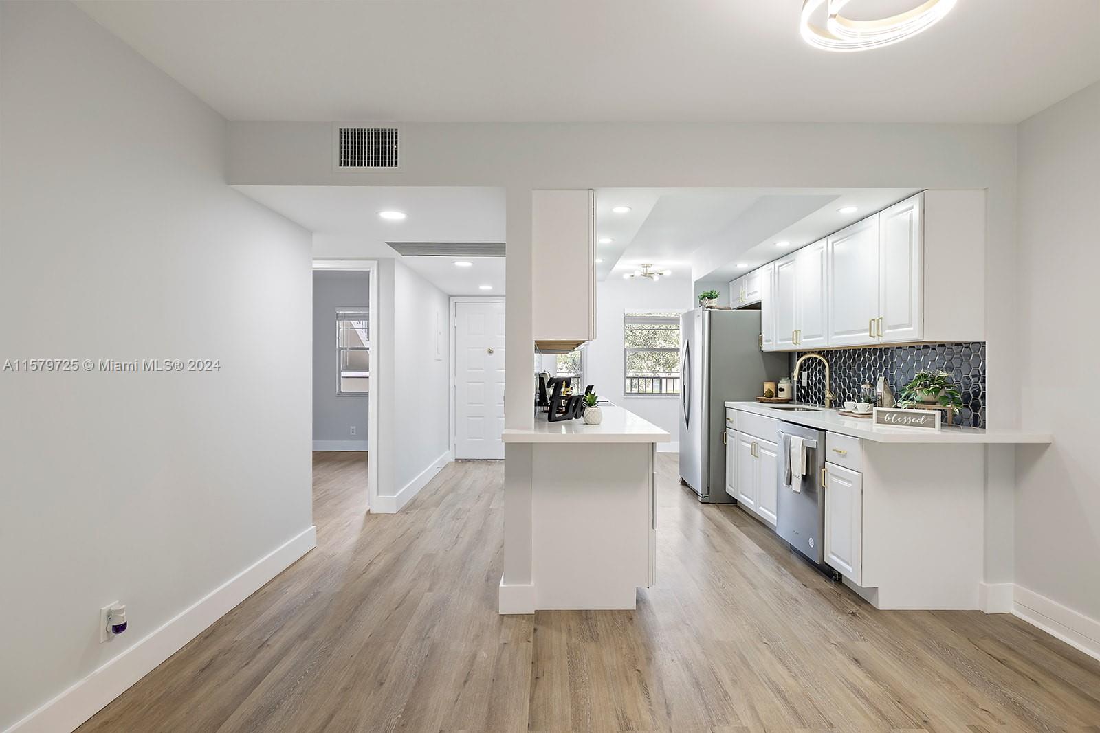 a large kitchen with a lot of counter space and stainless steel appliances